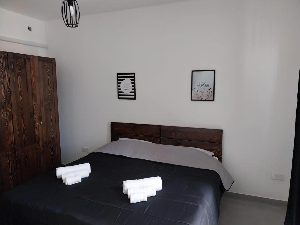 a bedroom with a black bed with two white towels at St Gaetan Accomodation APT 7 B 