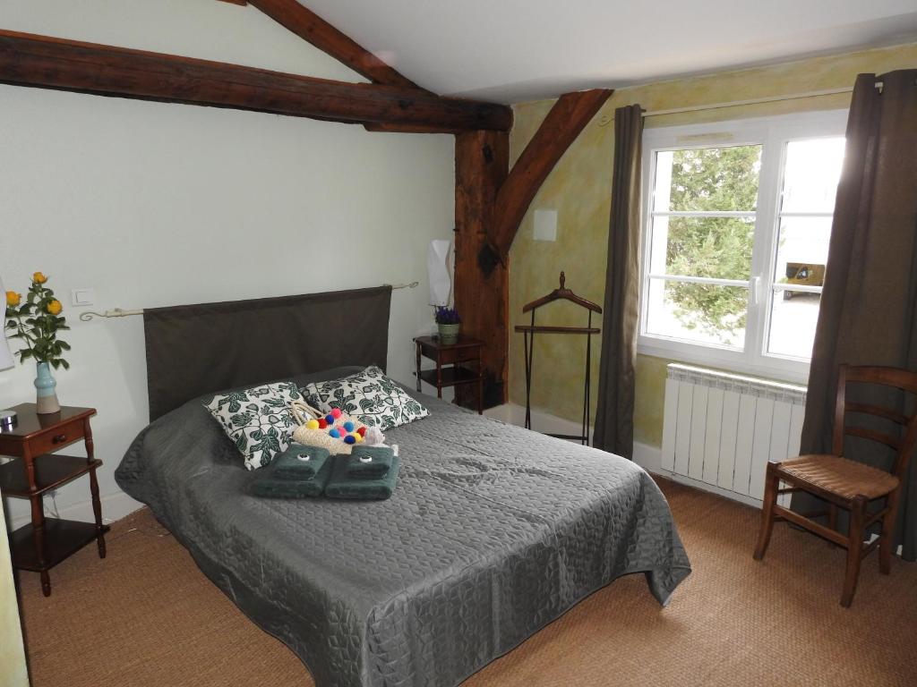 una camera con un letto in una stanza con una finestra di Le Moulin de Chamouilley a Chamouilley