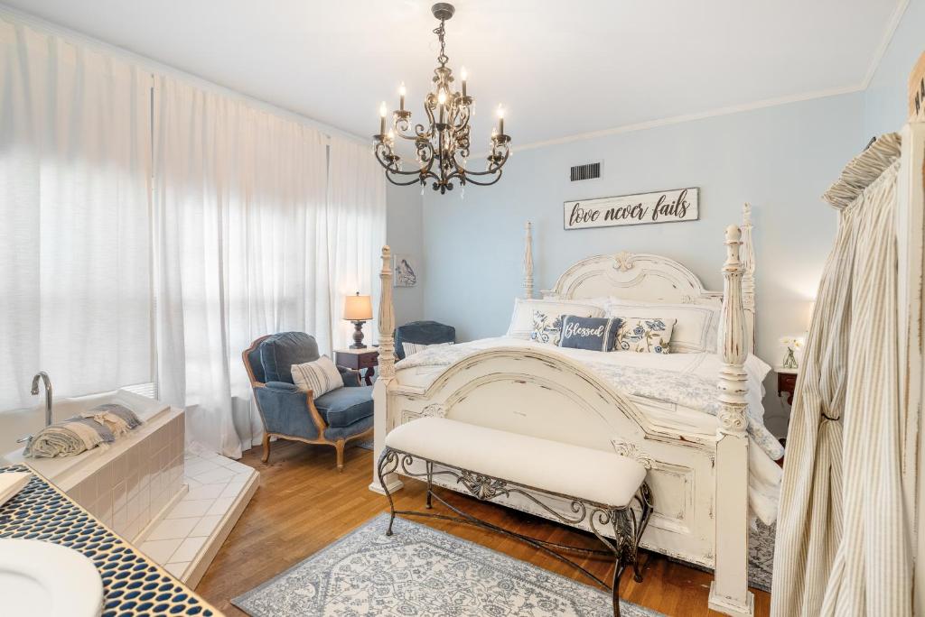 a bedroom with a white bed and a chandelier at Grand Mansion-Blue Jay suite! in Fort Smith