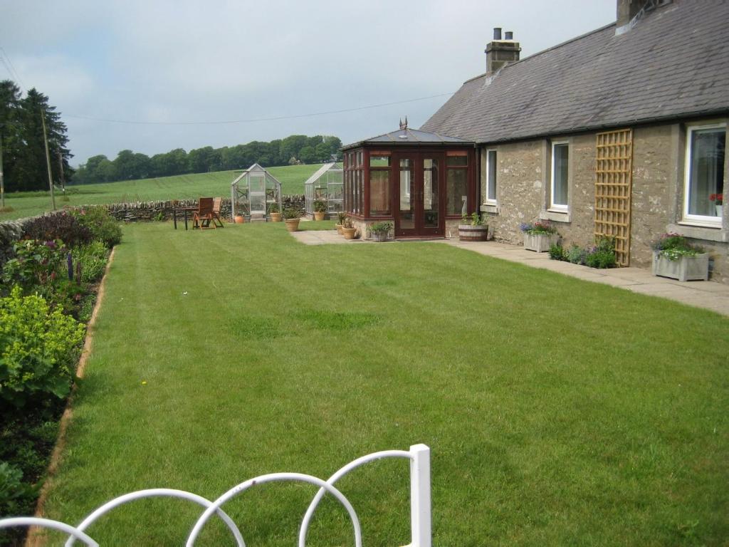 a backyard of a house with a green yard at 2 Bed in Carnoustie 58026 in Monikie