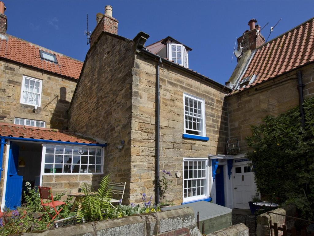 an old stone house with blue doors and windows at 2 Bed in Robin Hoods Bay G0085 in Robin Hood's Bay