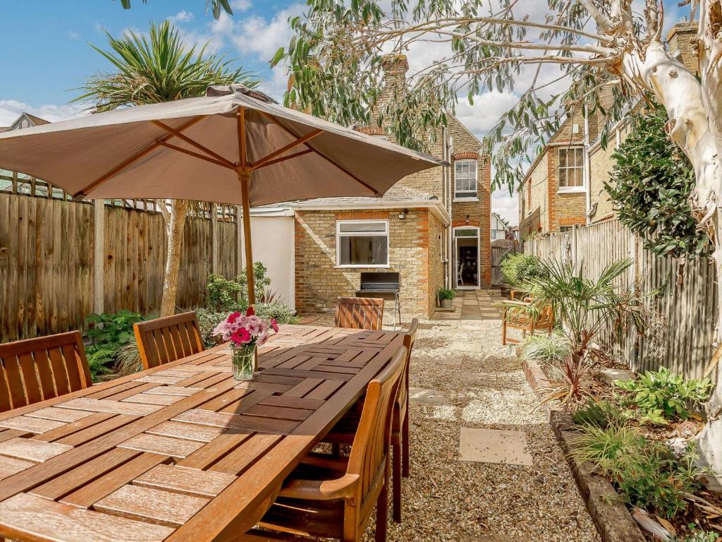 a wooden table with an umbrella in a backyard at 3 bed in Whitstable 88750 in Whitstable