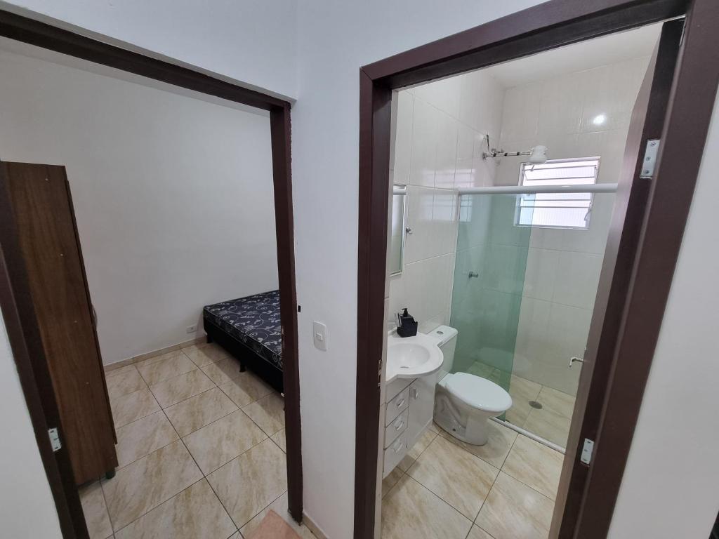 a bathroom with a toilet and a glass shower door at Flat 4 in Sao Paulo
