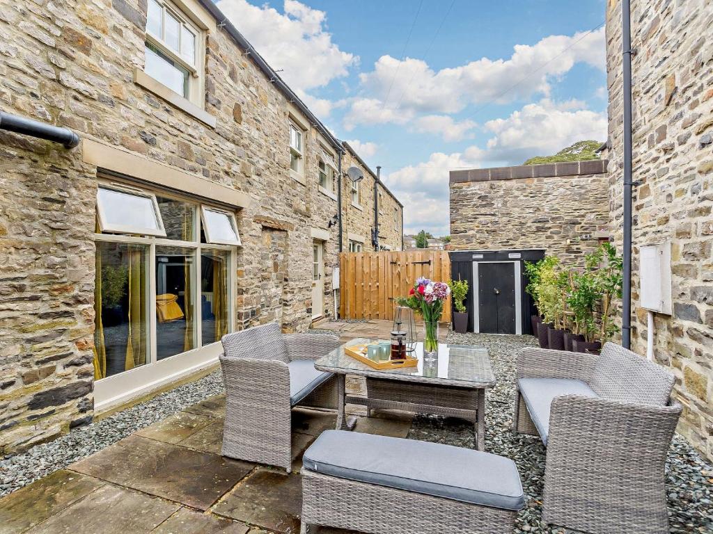 a patio with chairs and a table in front of a building at 2 Bed in Leyburn 93162 in Leyburn