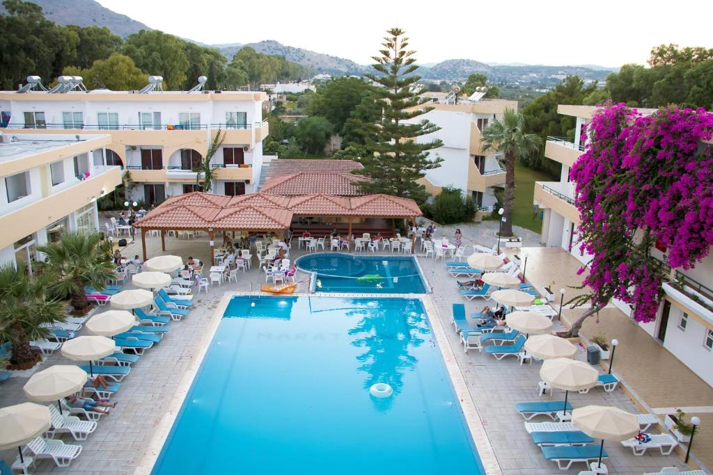 an aerial view of a hotel pool with chairs and umbrellas at Marathon Hotel - All Inclusive in Kolymbia