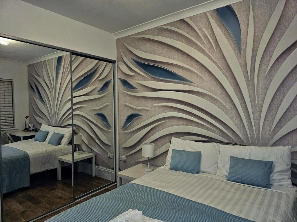 um quarto com 2 camas e um mural de parede em Rosie Blue em Londres