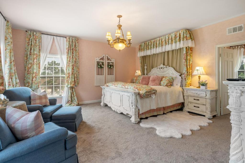 een slaapkamer met een bed en een blauwe bank bij Grand Mansion-Blushing Rose in Fort Smith