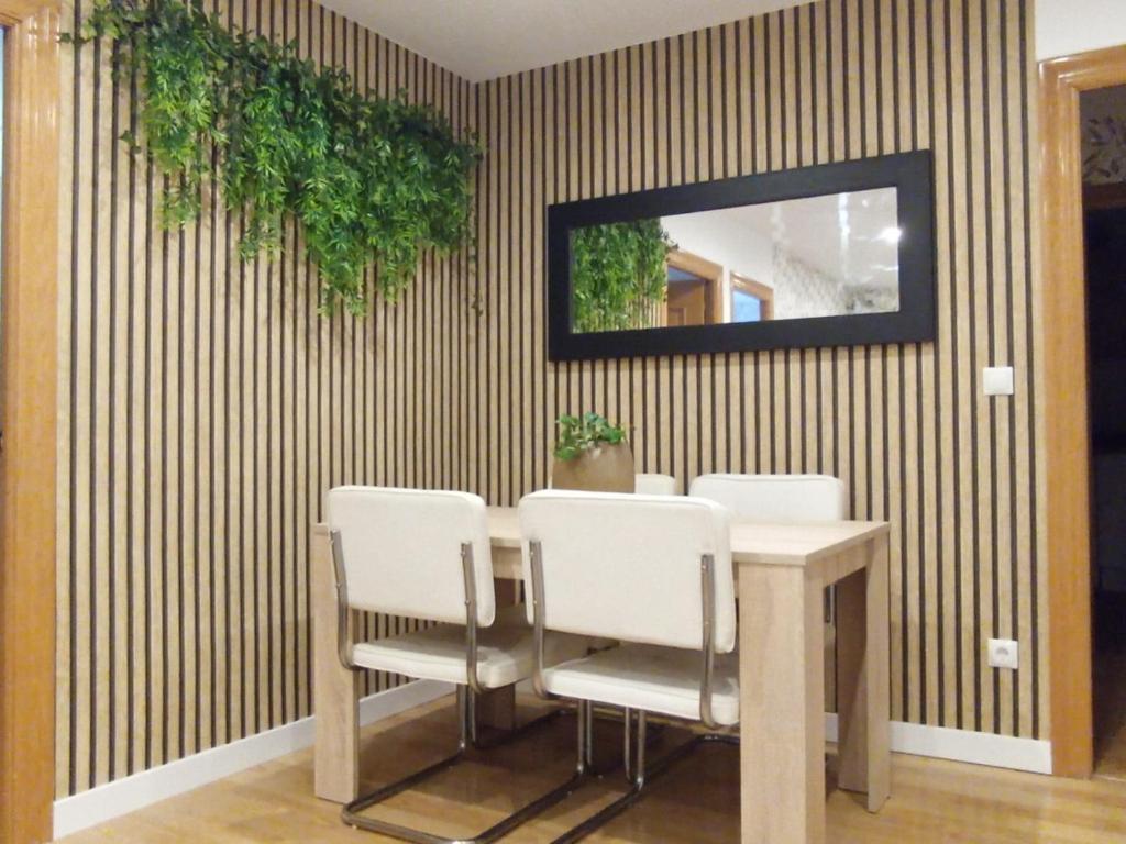 uma sala de jantar com uma mesa com cadeiras e um espelho em Apartamento Peace Home Astillero em El Astillero