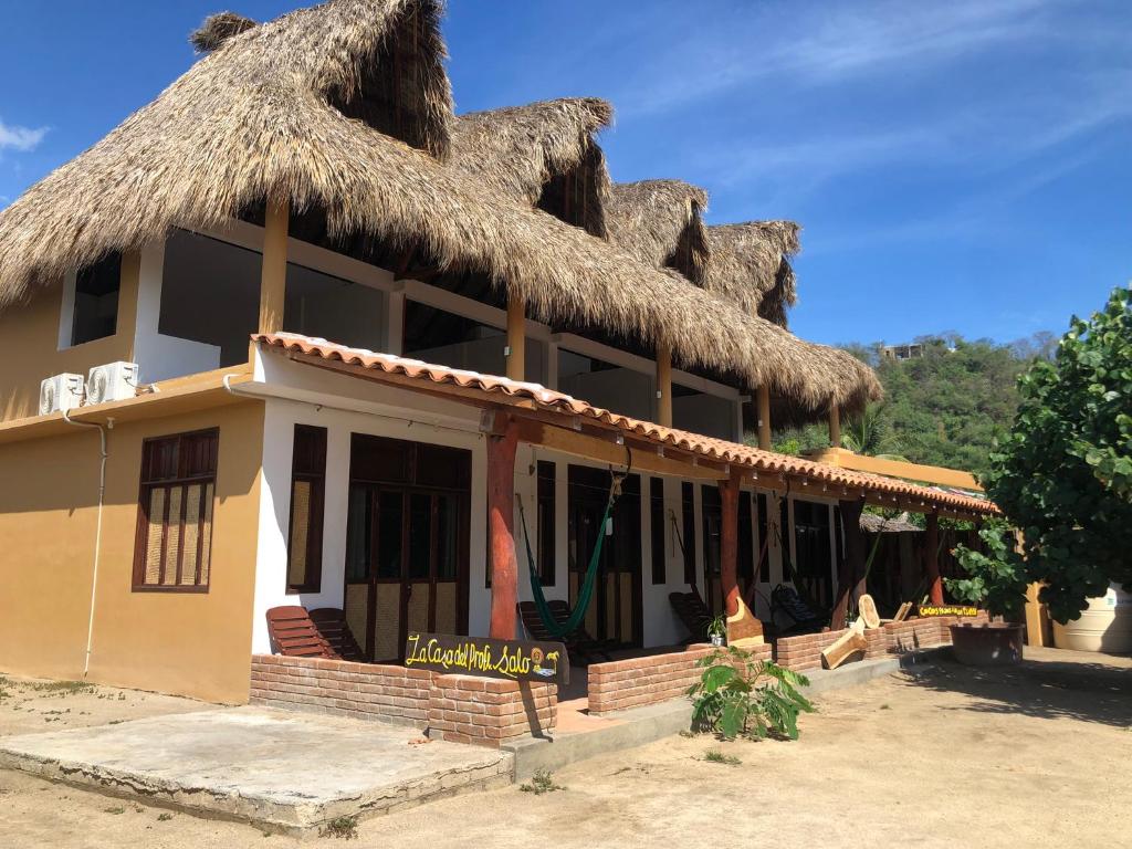 um edifício com telhado de palha em Hab #1 La Casa del Profe Salo em Santa María Tonameca