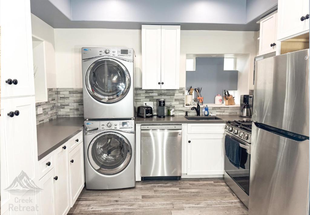 a kitchen with stainless steel appliances and white cabinets at The Creek Retreat - Totally private 1Br/1Bd 