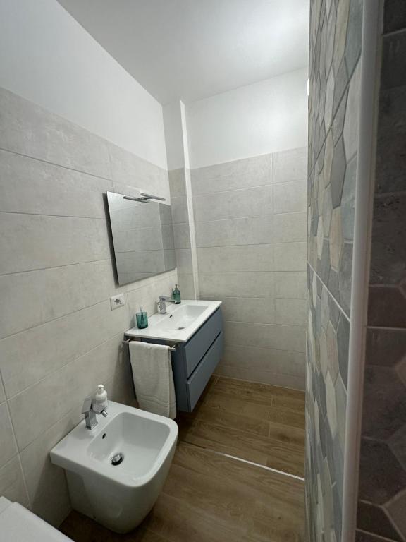 a white bathroom with a sink and a mirror at La casa del fumetto in Castel di Sangro