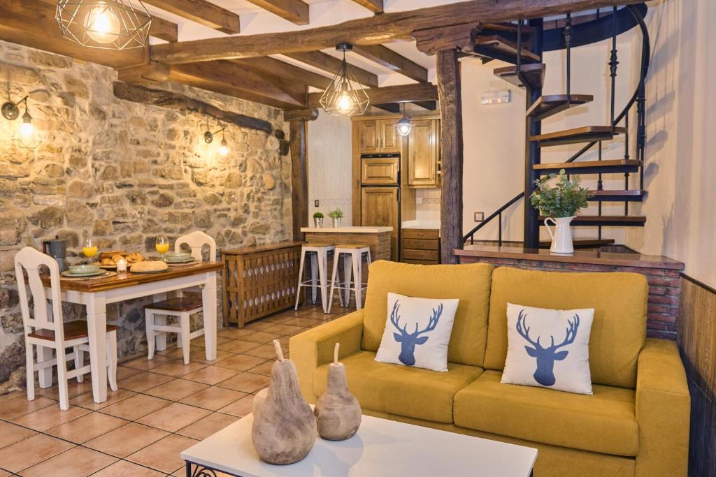 - un salon avec un canapé jaune et une table dans l'établissement Casa Rural Tia Josefa, à Lon