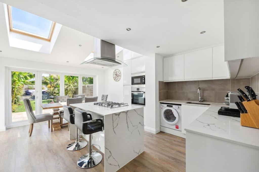 a kitchen with white cabinets and a kitchen island at Richmond Riverside Villa in Richmond
