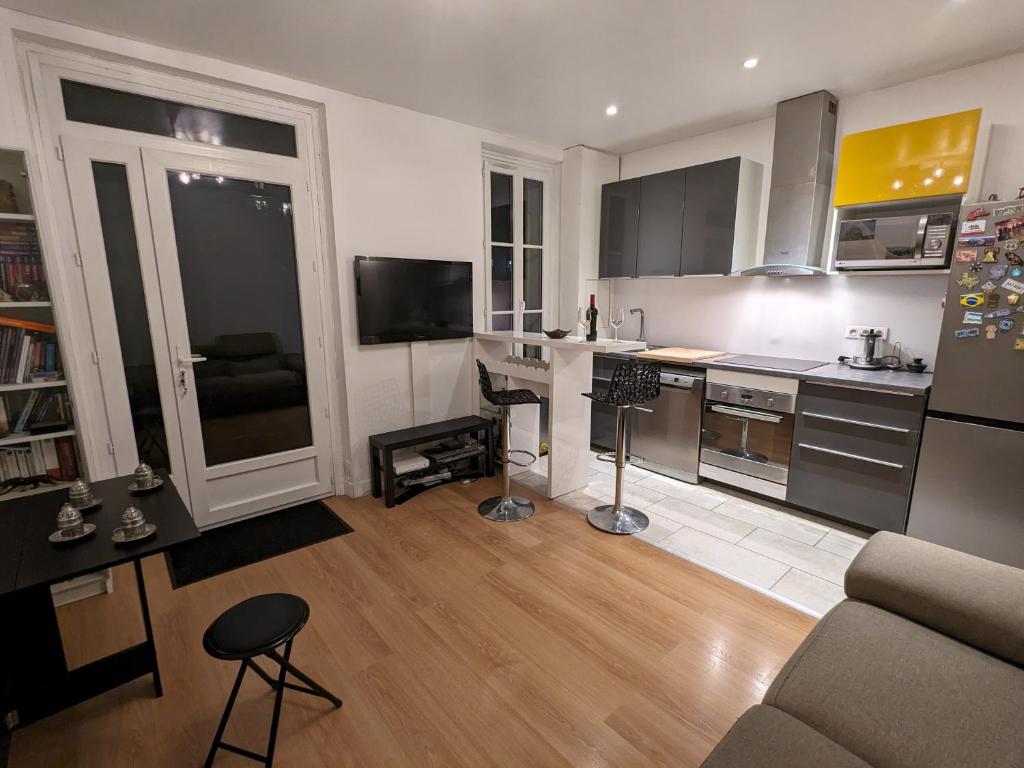 ein Wohnzimmer mit einer Küche mit einem Sofa und einem Tisch in der Unterkunft Appartement 2 pièces proche de Paris in Charenton-le-Pont