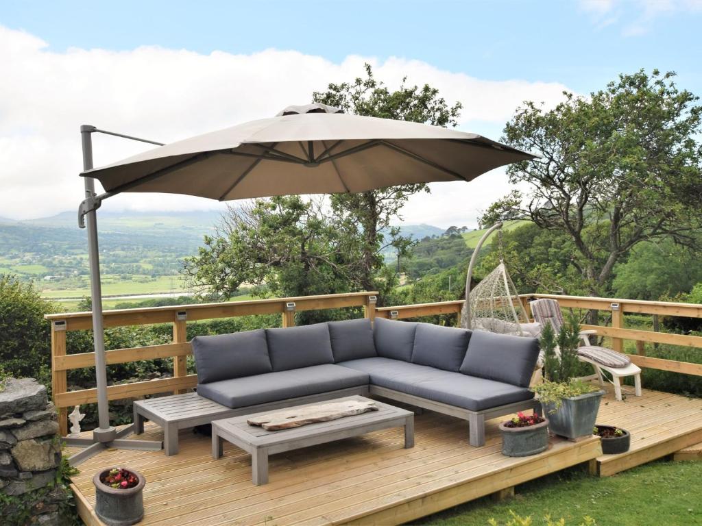 a couch on a deck with an umbrella at 2 bed in Conwy Valley SKN09 in Llanrwst