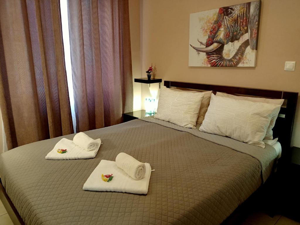 een slaapkamer met een bed met handdoeken erop bij Myilios by Ilios Company in Athene