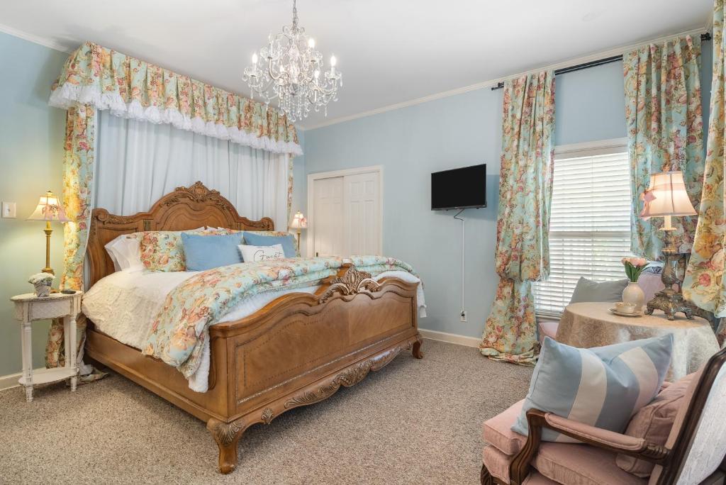 ein Schlafzimmer mit einem großen Bett und einem Kronleuchter in der Unterkunft Grand Mansion-Treasured Mist suite! in Fort Smith