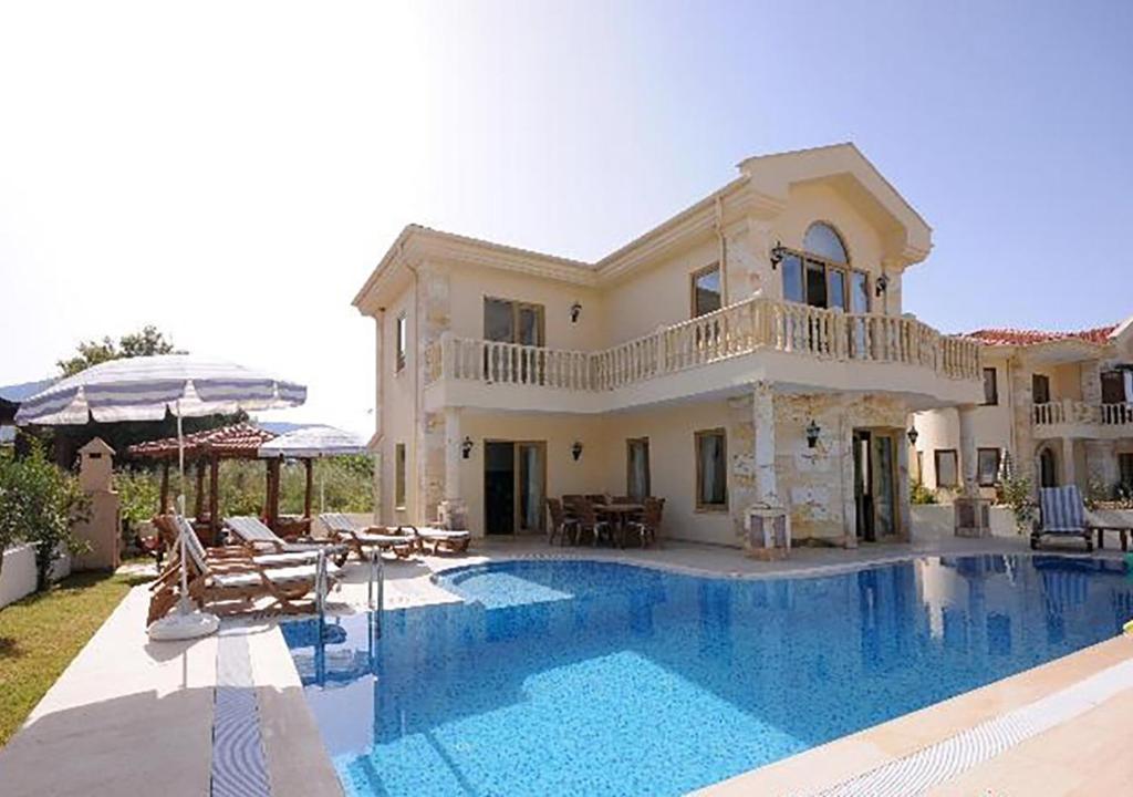a large house with a swimming pool in front of it at RUMUZLUKONUT in Bodrum City