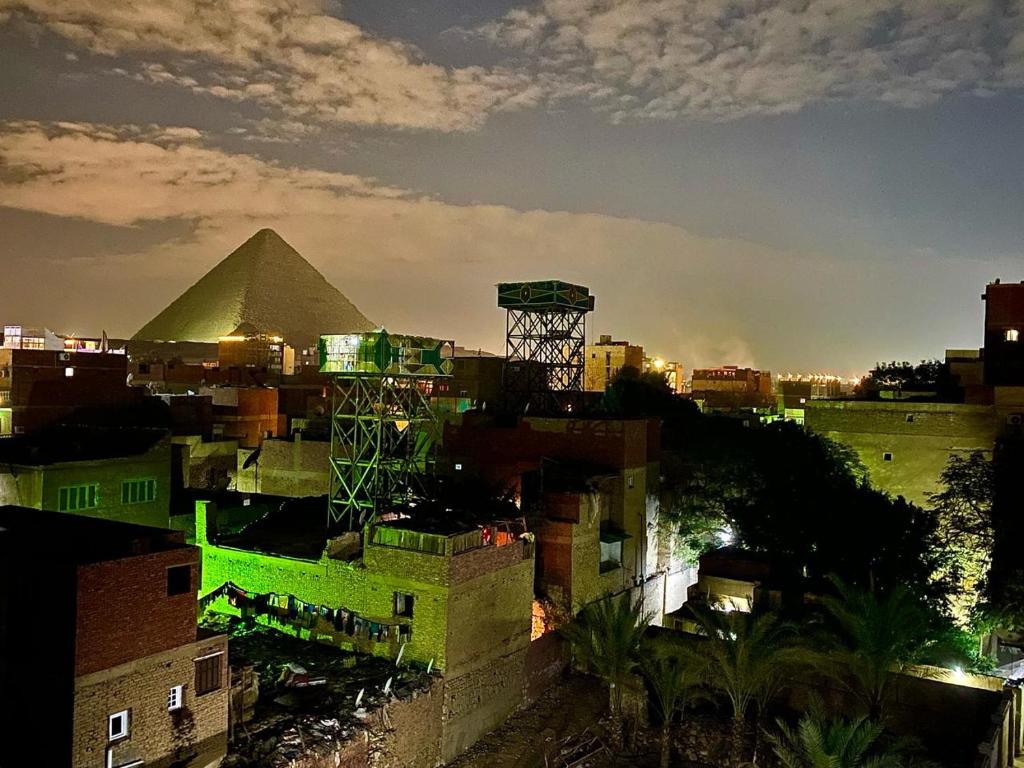 una vista de las pirámides desde una ciudad por la noche en Studio Merit Pyramids View, en El Cairo