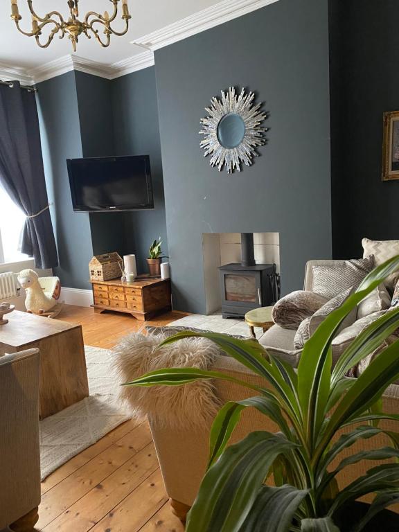 a living room with a couch and a fire place at Specious City Victorian House in Plymouth