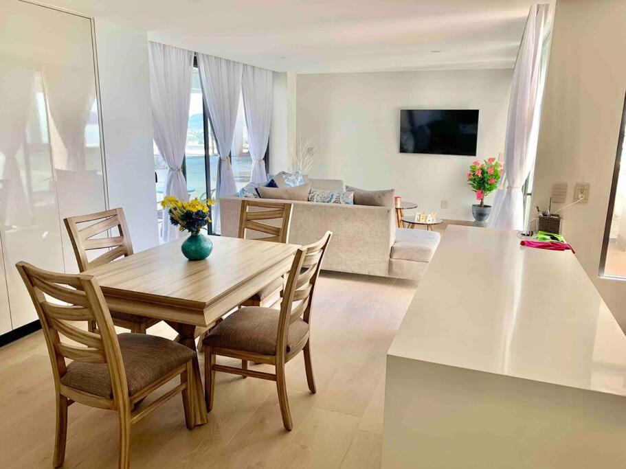 a dining room table and chairs in a living room at Ocean View Condo in Mazatlán