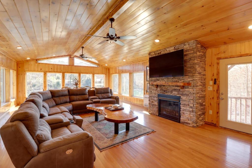 a living room with a couch and a fireplace at Family-Friendly Riverfront Manor on the Little Red in Heber Springs