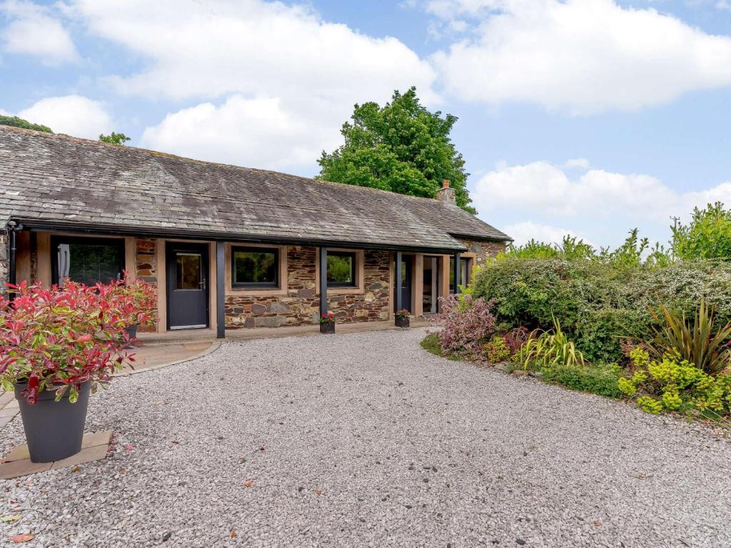 an old stone cottage with a gravel driveway at 2 Bed in Ullswater 80556 in Watermillock