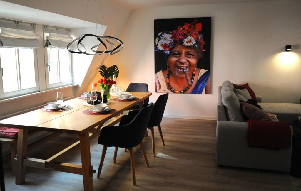 a living room with a table and a painting of a woman at Deluxe-Apartment Altstadt in Ettlingen