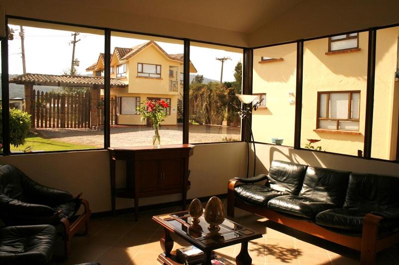 a living room with a view of a house at hotel el portal de las Flores, Alojamiento Rural in Chía