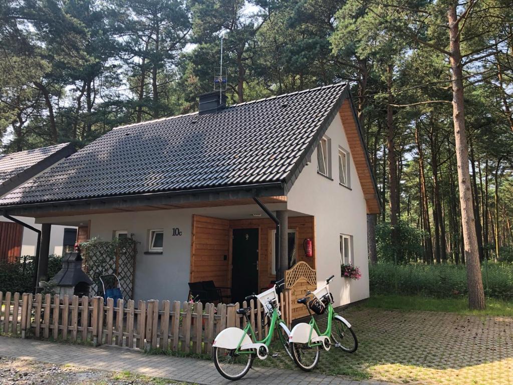 a house with two bikes parked in front of it at Domek pod lasem in Pogorzelica