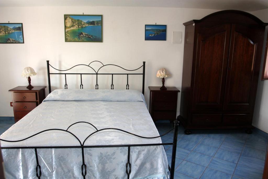 ein Schlafzimmer mit einem großen Bett und zwei Nachttischen in der Unterkunft HOTEL SANTA CLARA in Camerota