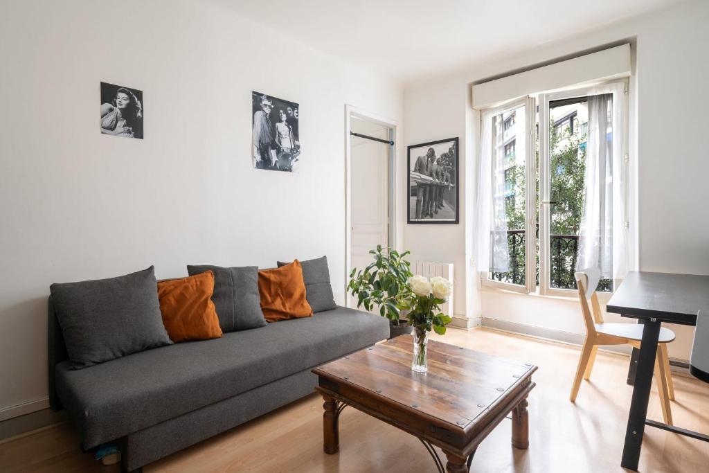 un salon avec un canapé et une table dans l'établissement Appartement Bolivar - Welkeys, à Paris