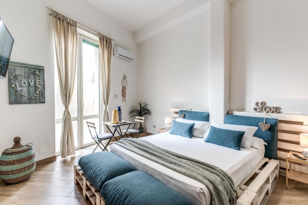 um quarto com uma cama grande e almofadas azuis em Le Mura Antiche em Nápoles