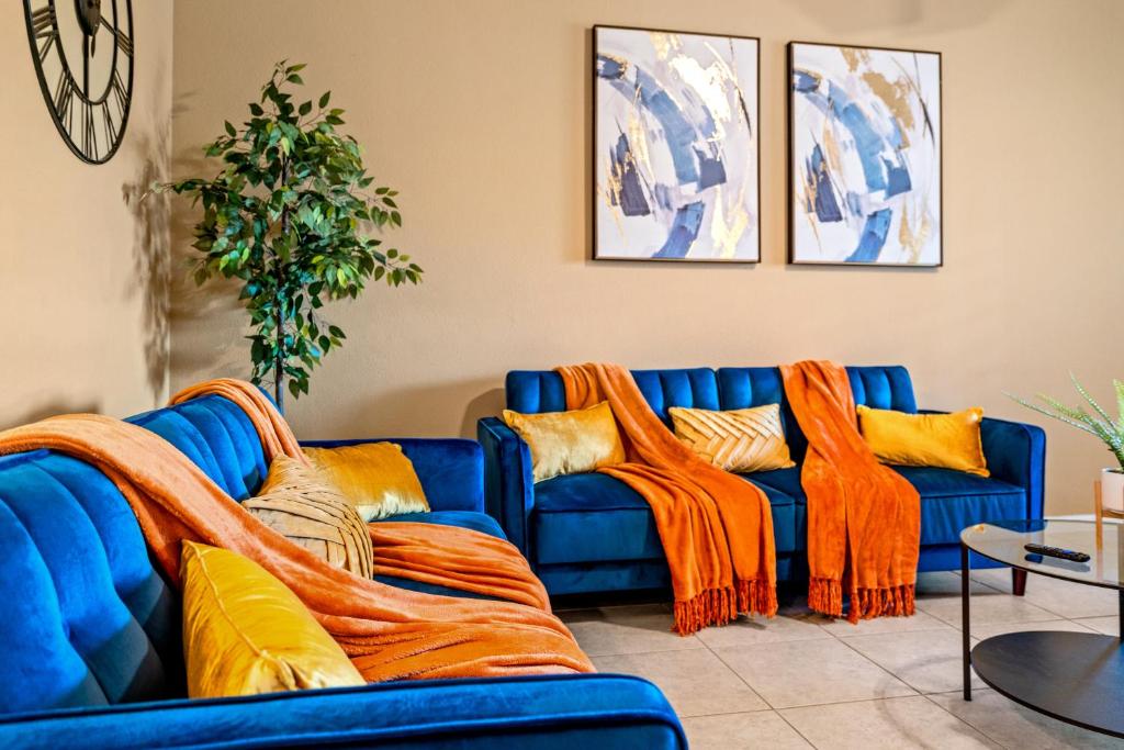 a blue couch with orange cushions in a living room at Crowley Home w/Wi-Fi & Foosball in Crowley