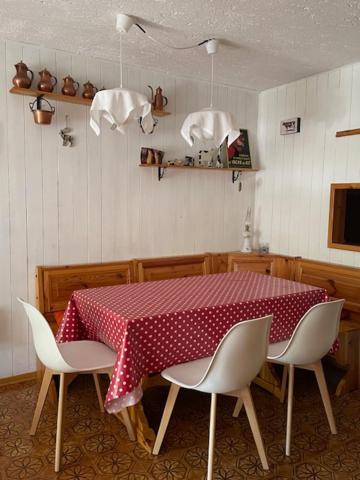 ペーイオ・フォンティにあるGrazioso appartamento nel cuore della Val di Soleのダイニングルームテーブル(赤と白のテーブルクロス付)