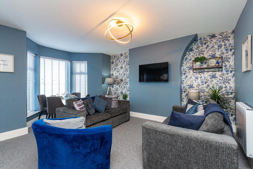 uma sala de estar com paredes azuis e sofás em Modern Seafront 2 Bedroom Apartment - Brand New em Morecambe
