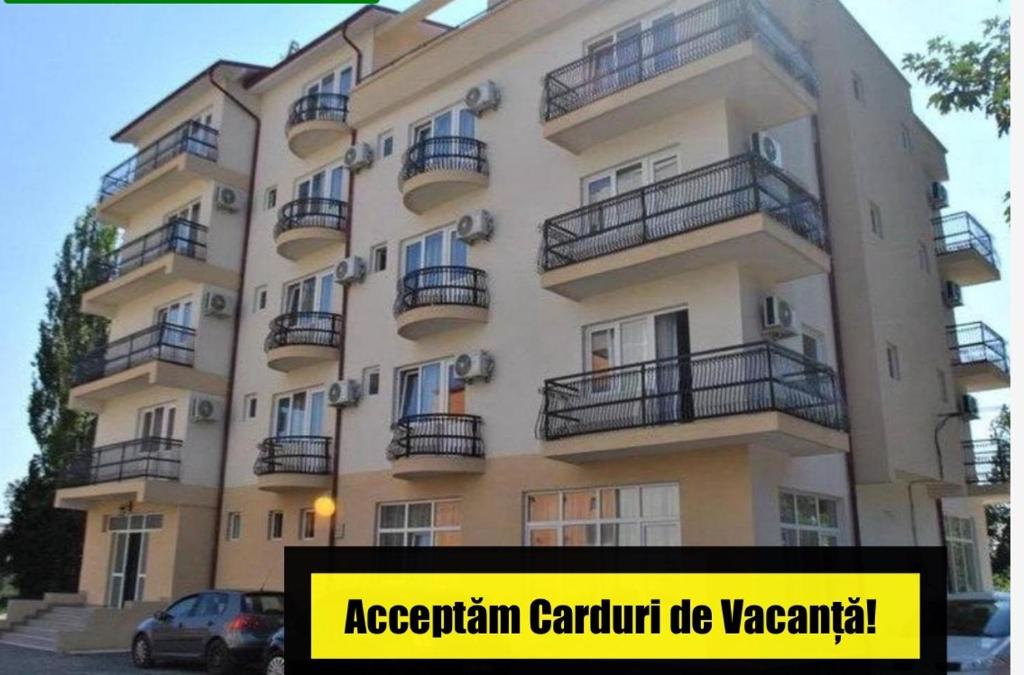 un gran edificio con balcones y una señal frente a él en Casa Mario, en Eforie Nord