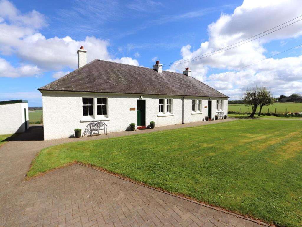 a white house with a large grass yard at 3 bed in Auldearn CA209 in Nairn