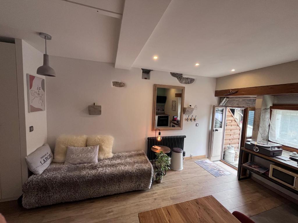 ein Wohnzimmer mit einem Sofa auf einem Holzboden in der Unterkunft Studio l’Atelier des rêves in Divonne-les-Bains