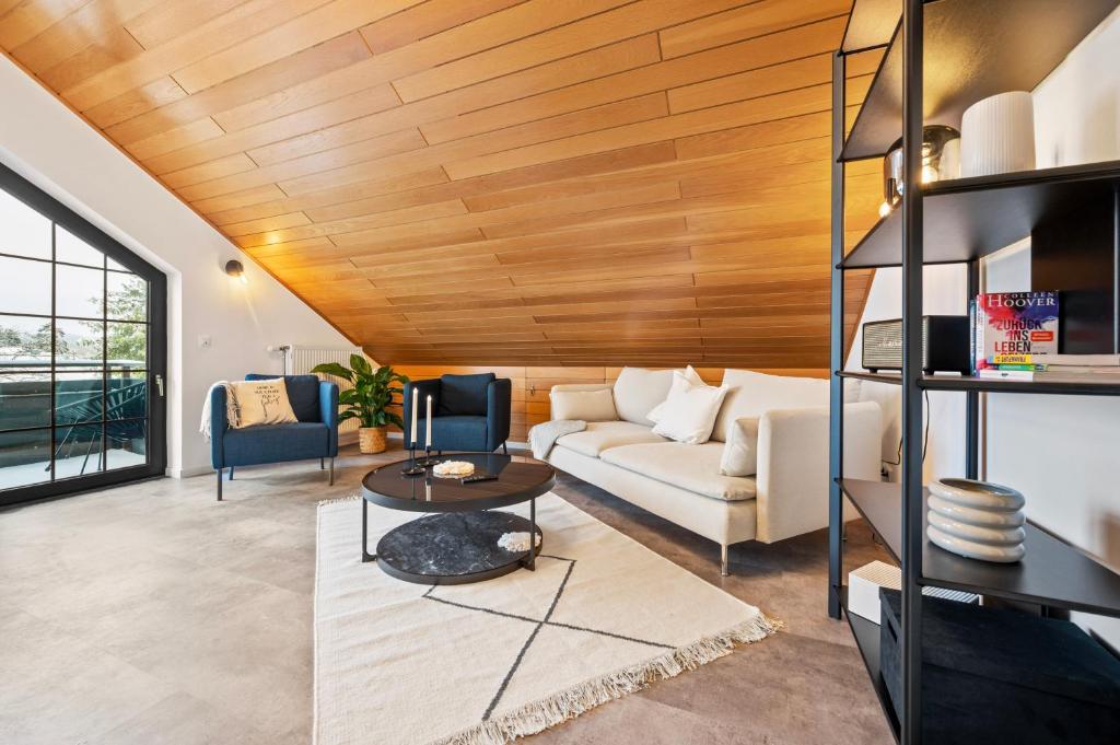 a living room with a white couch and wooden ceiling at Wohnung Weitblick in Neu-Anspach