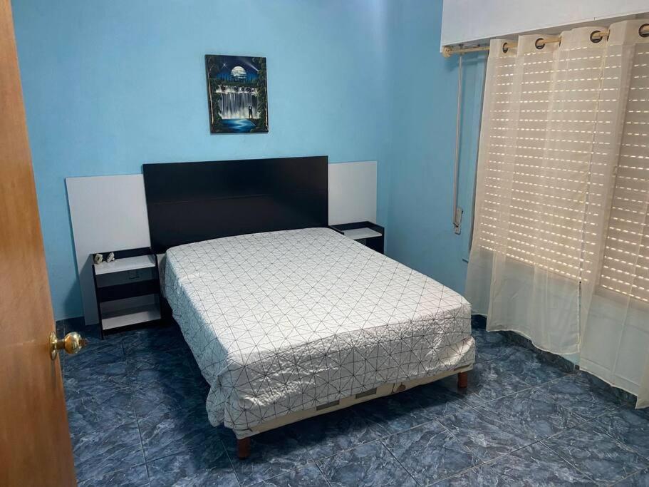 um quarto com uma cama num quarto azul em Sin Pensarlo 