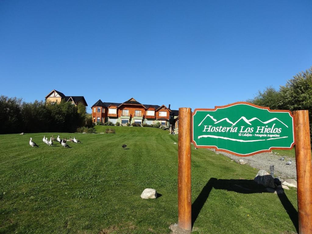 una señal en un campo con un grupo de aves en Hosteria Los Hielos en El Calafate