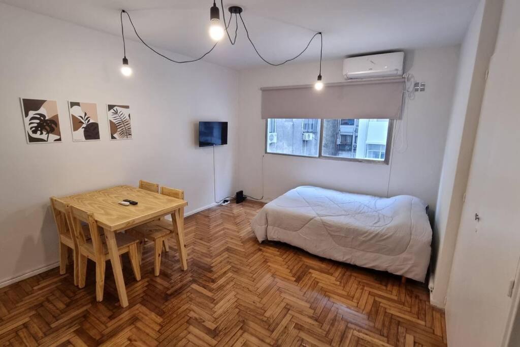 1 dormitorio con cama, mesa y escritorio en Monoambiente en Buenos Aires en Buenos Aires