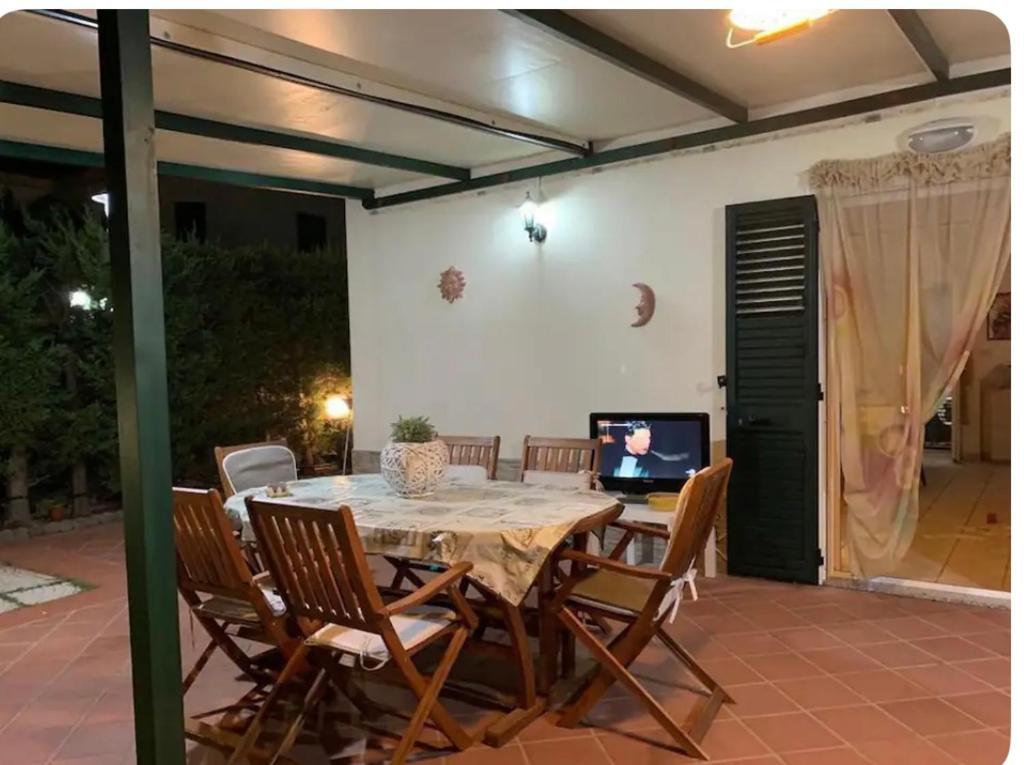 a dining room table with chairs and a television at Villa Melania in Rossano