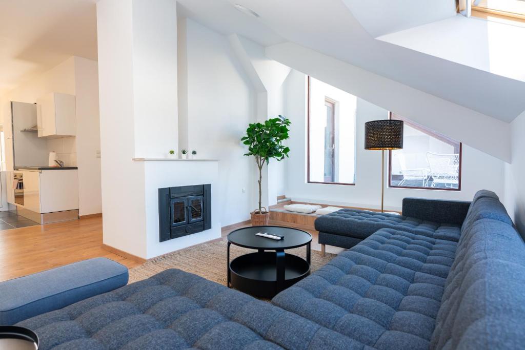 sala de estar con sofá azul y chimenea en Luxury Penthouse - Augarten, en Viena