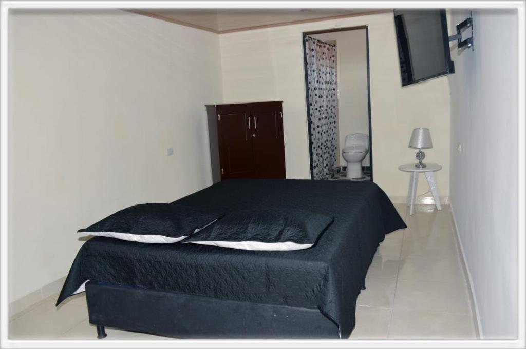 a bedroom with a bed with a black blanket at Familia angel in Dosquebradas