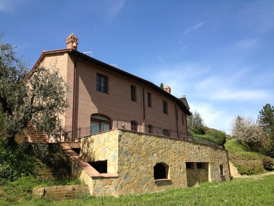 ein altes Steinhaus mit Balkon darüber in der Unterkunft Casa Vacanze Verdoliva in San Miniato