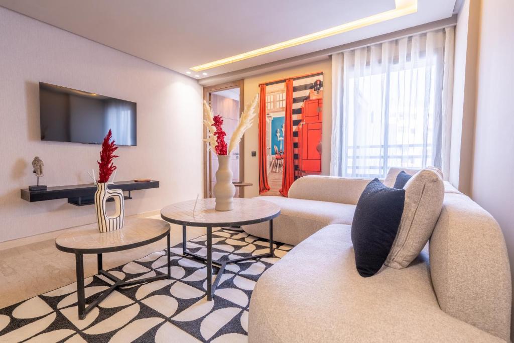 ein Wohnzimmer mit einem Sofa und 2 Tischen in der Unterkunft Luxoria by SHORTSTAYCASA- New & Chic in the heart of town in Casablanca