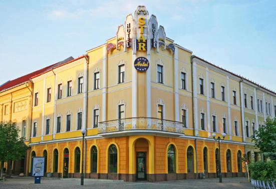 a large yellow building with a sign on it at Hotel Star in Mukacheve