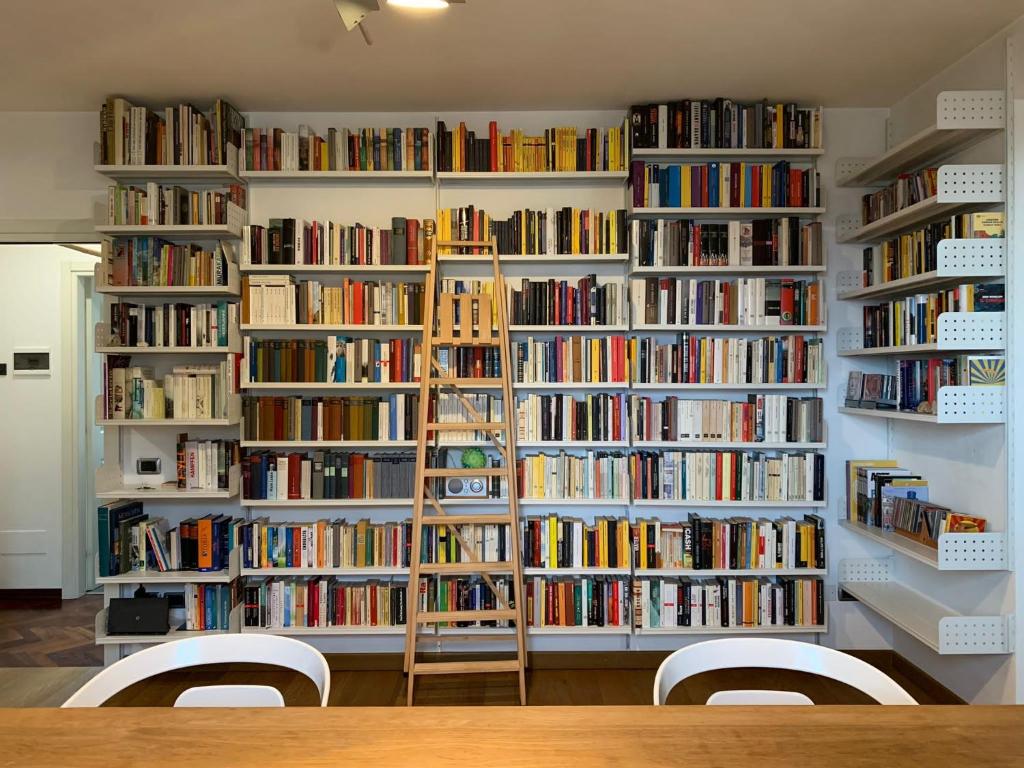 een kamer met meerdere boekenplanken gevuld met boeken bij Casa Paslawski in Corciano